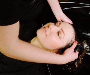 Girl getting hair shampooed in shampoo bowl