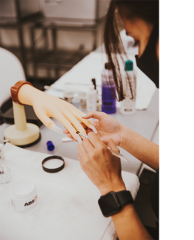Nail tech learning to paint nails on a mannequin